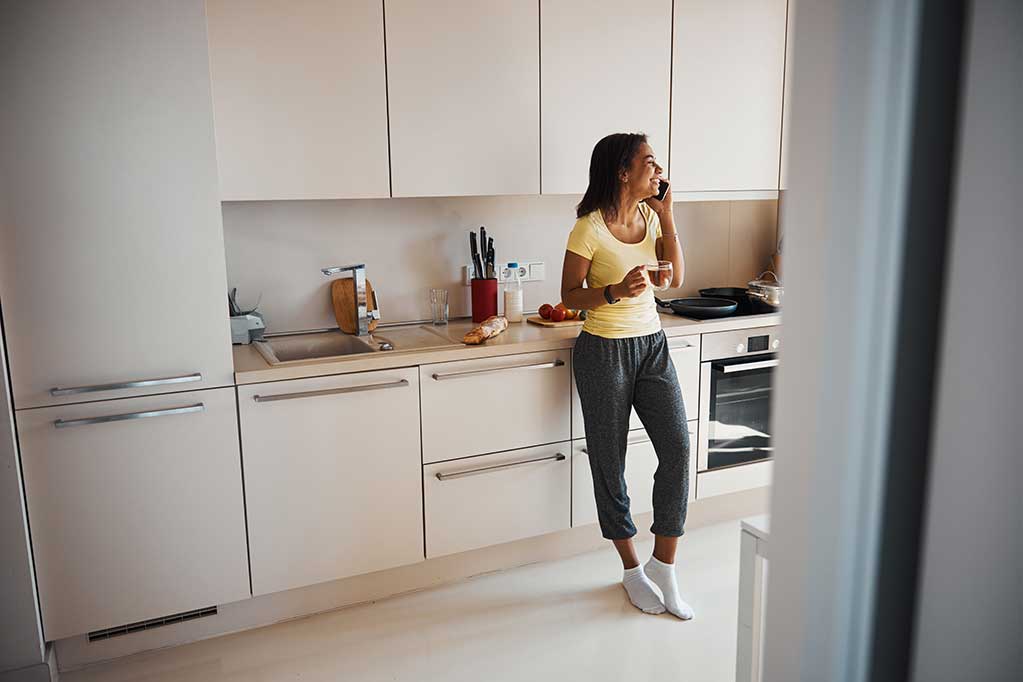 cheerful-young-woman-talking-on-mobile-phone-at-ho-2024-10-18-08-38-28-utc